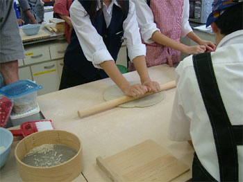 麺棒で生地を伸す生徒