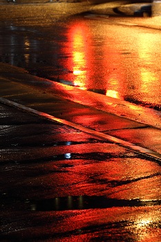 濡れた地面が街灯で照らされた情景